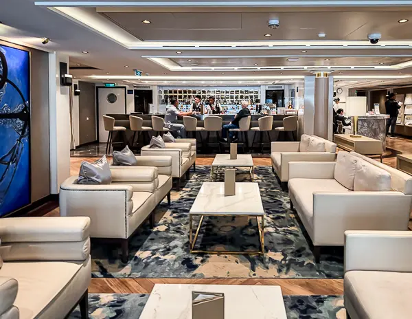 The Haven Lounge and Bar on Norwegian Encore, featuring modern seating and a central bar exclusive to Haven guests