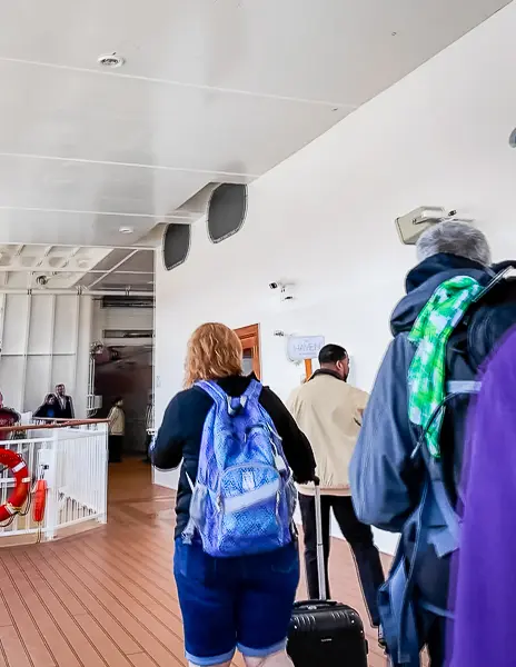 The Haven guests being personally escorted onto the Norwegian Encore by staff holding a Haven sign during embarkation