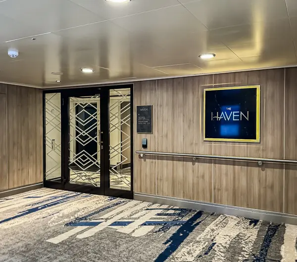 Private entrance to The Haven on Norwegian Encore, featuring a sign and secure access doors leading into the exclusive suite area