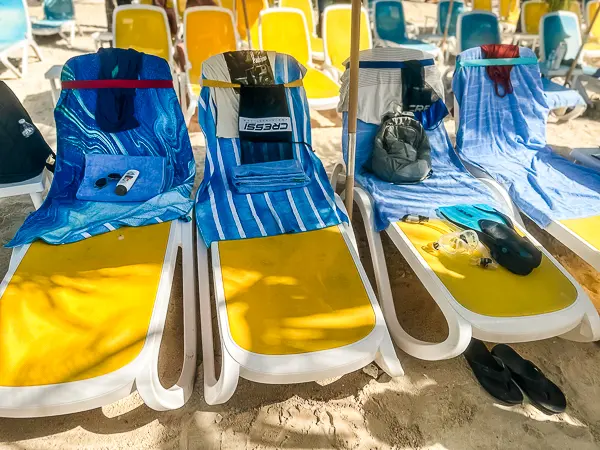 Beach chairs at CocoCay with towels secured by towel bands, showing how they help keep towels in place at the beach.