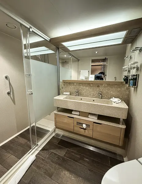 Double vanity and walk-in shower inside the bathroom of Norwegian Getaway’s The Haven Suite 14138.