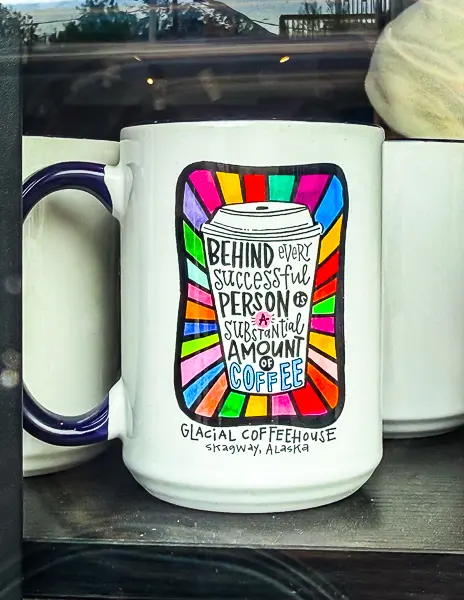 Mug from Glacial Coffeehouse in Skagway, Alaska, with colorful design and the phrase “Behind every successful person is a substantial amount of coffee.”