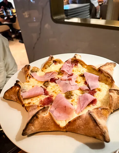 Star-shaped Macellaio pizza topped with ham at Onda by Scarpetta on the Norwegian Encore