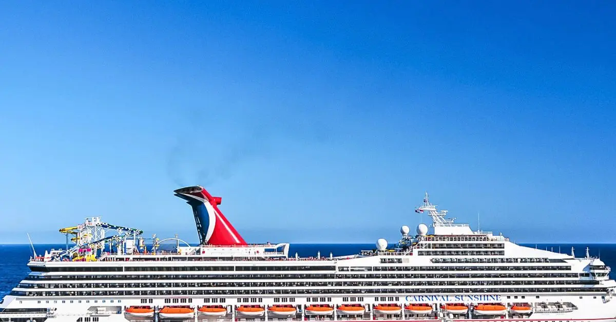 featured image: Carnival Sunshine cruise ship sailing at sea under a clear blue sky, featured in a Carnival cruise packing list of essential items to bring.
