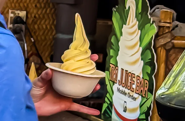 Close-up of a Dole Whip at Disneyland's Tiki Juice Bar with a Mobile Order sign in the background