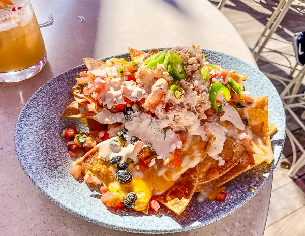 Lobster nachos topped with cheese, pico de gallo, jalapeños, and sauce at Lamplight Lounge in Disney California Adventure.