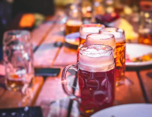 Glass steins of beer on a wooden table at Oktoberfest in Munich, Germany.