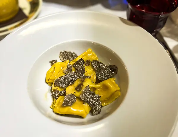 Plate of fresh pasta topped with shaved black truffles in Italy.