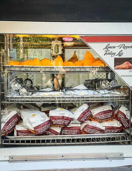 Display case of wrapped turkey legs at Disneyland, including the lemon pepper flavor.