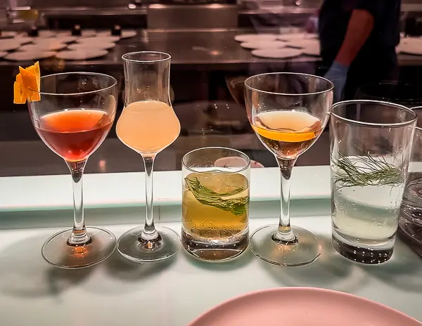 A row of colorful cocktails served on a cruise ship, tying into drink package tips and the importance of pacing yourself while drinking on board.