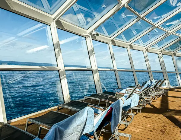 Cruise ship lounge chairs covered with towels along the pool deck, a common example of chair hogging on cruises