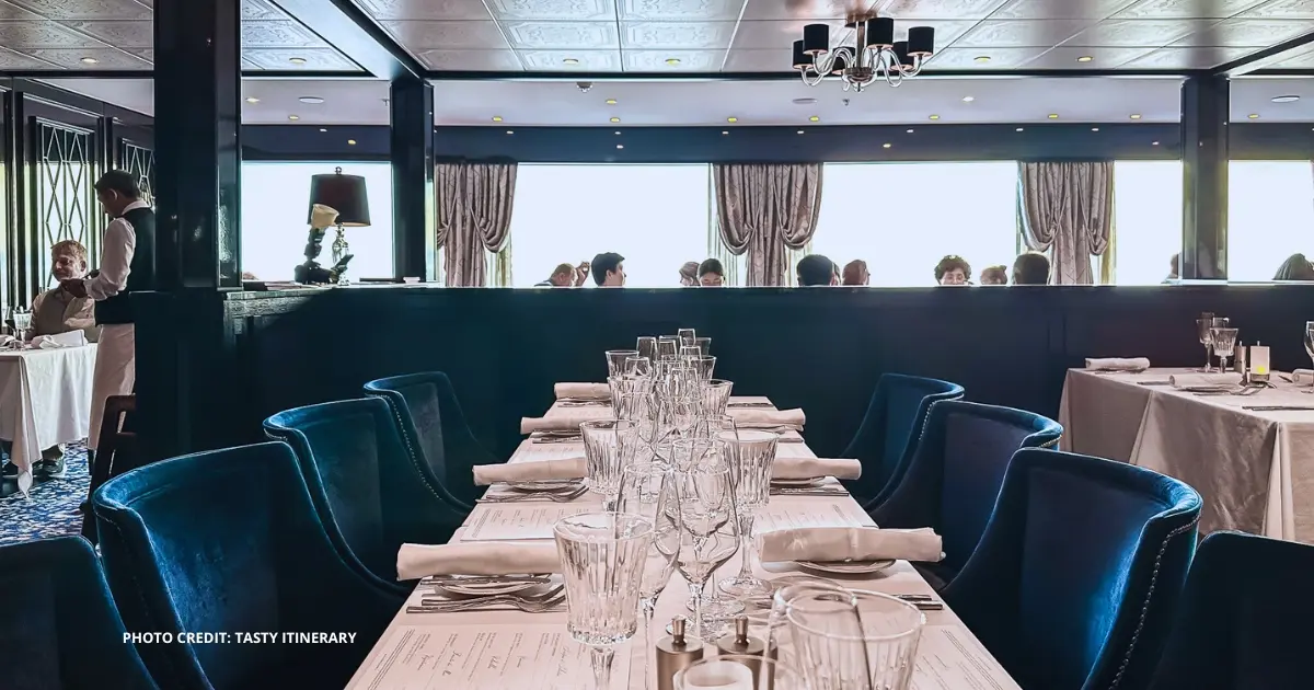 featured image: Elegant table setting at Le Bistro, a French specialty restaurant on a Norwegian Cruise Line ship, related to NCL’s new no-show dining policy.