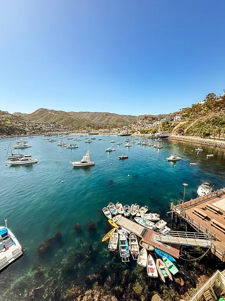 Scenic view of Avalon Bay from the Catalina Casino, with boats in the harbor and hillside homes in the distance.