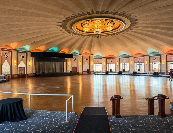 Interior of the Catalina Casino Ballroom with hardwood floors, circular design, and a grand chandelier centerpiece.