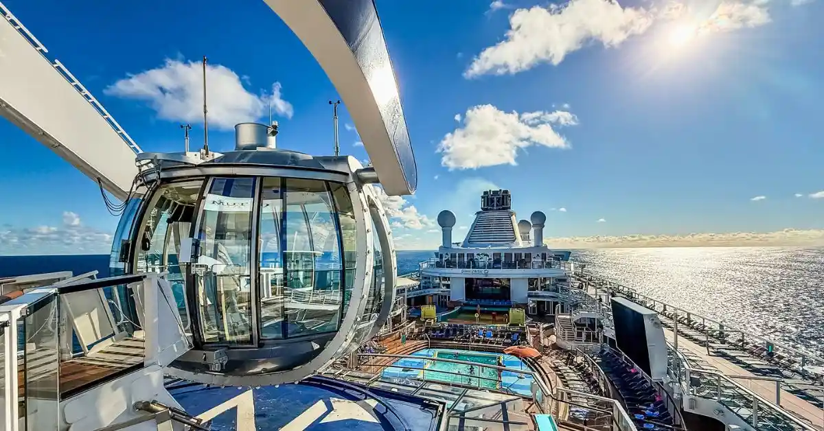 View from the upper deck of Royal Caribbean’s Quantum of the Seas, showing the North Star capsule, outdoor pools, and ocean on a sunny sea day. Featured image for the Royal Caribbean’s Quantum of the Seas Review.