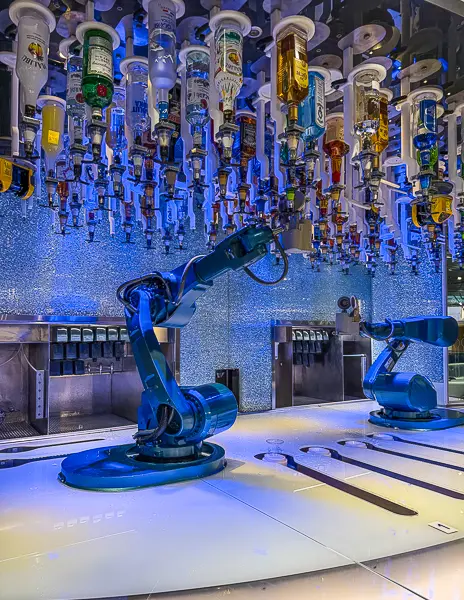 Close-up of the robot bartenders at the Bionic Bar on Quantum of the Seas, mixing drinks beneath the suspended liquor system.