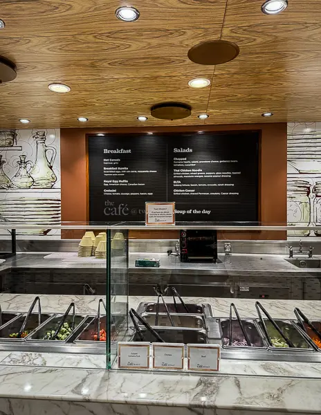 Salad bar setup at Café Two70 on Quantum of the Seas, with the breakfast and salad menu displayed on the wall above the counter.