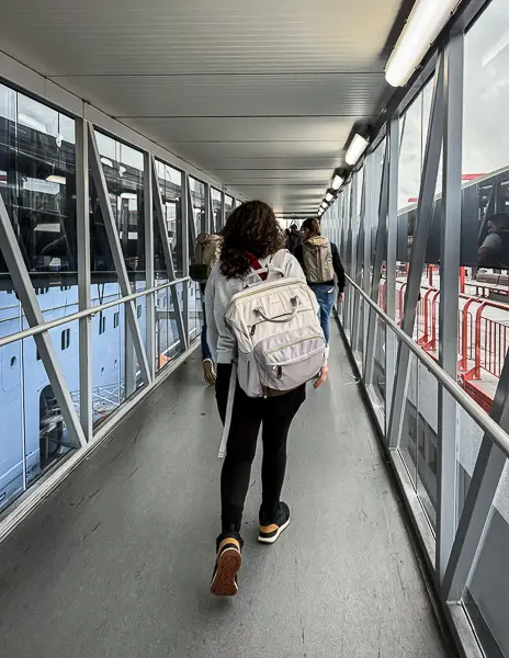 Kathy and passengers walking down the enclosed gangway toward Quantum of the Seas during embarkation at the Port of Los Angeles.