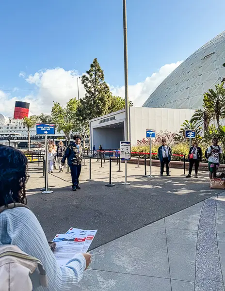 Passenger walking toward the Long Beach Cruise Terminal check in area, showing the familiar routine of cruising from a local homeport.