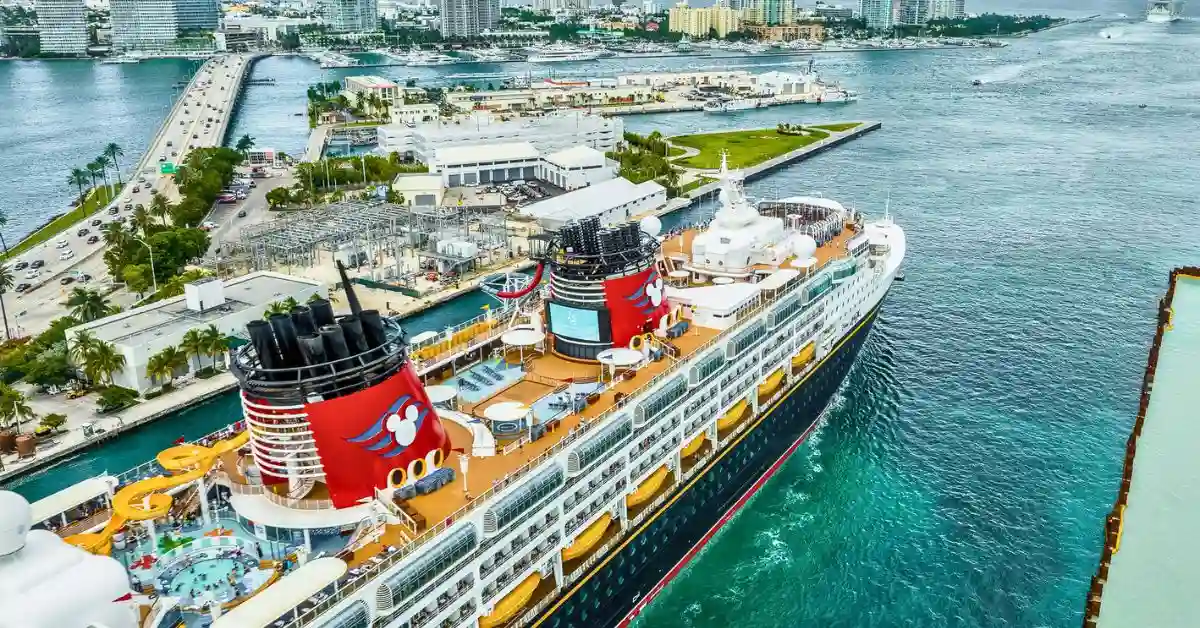Aerial view of a Disney Cruise Line ship departing port, used as a featured image for Disney Cruise Line cruise tips before you sail.