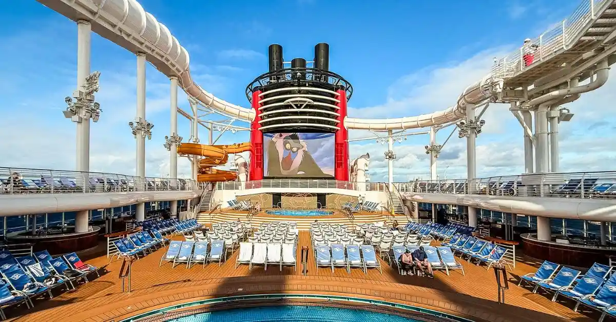 featured image: Disney cruise ship pool deck with waterslides and outdoor movie screen featured in Disney Cruise Line tips guide.