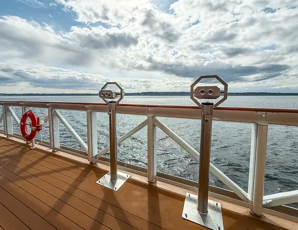 Cruise ship outer deck with ocean views and binocular stations, showing one way to explore the ship on a sea day.