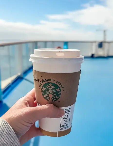 Starbucks specialty coffee on an outdoor cruise ship deck during a sea day, showing one way to enjoy food and drink options onboard.