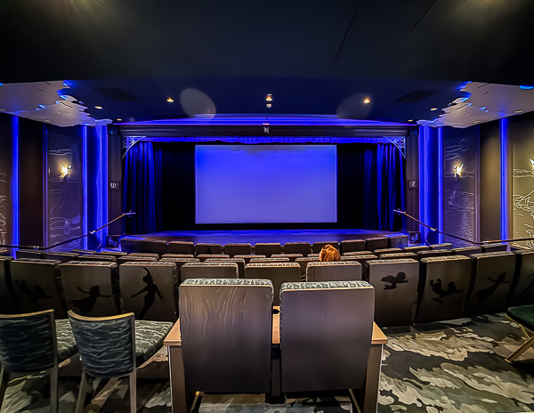Movie theater on a Disney cruise ship with large screen and theater seating.