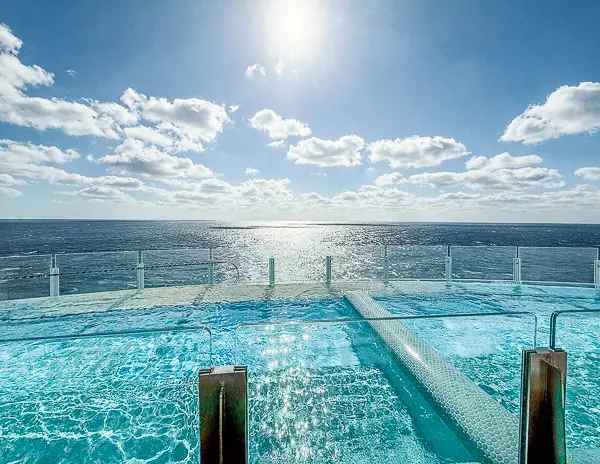 Infinity-style pool at Quiet Cove on Disney Treasure overlooking the open ocean.