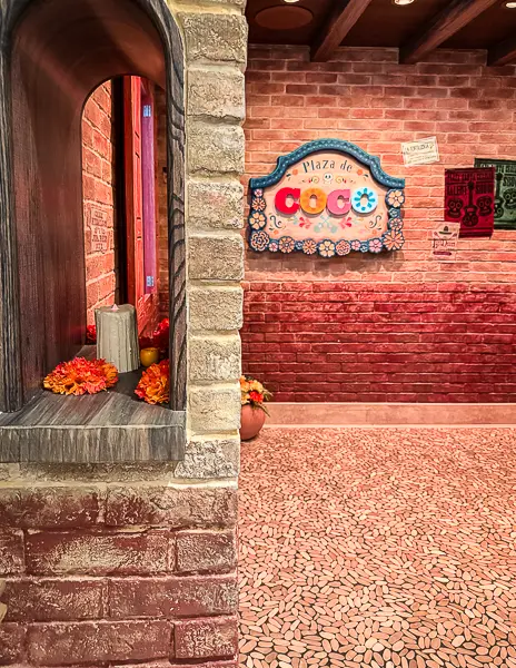 Entrance to Plaza de Coco restaurant on Disney Treasure with brick walls, colorful Coco signage, and festive Mexican-inspired décor.