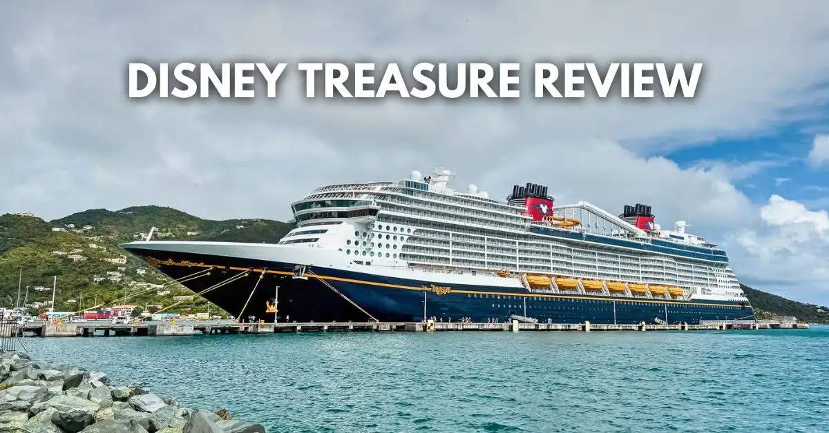 featured blog image: Disney Treasure cruise ship docked in Tortola port with green hills in the background and blue water in the foreground, and overlay text reading “Disney Treasure Review.”