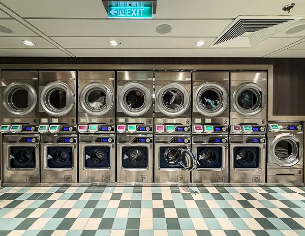 Self-service laundry room with washers and dryers onboard Disney Treasure.