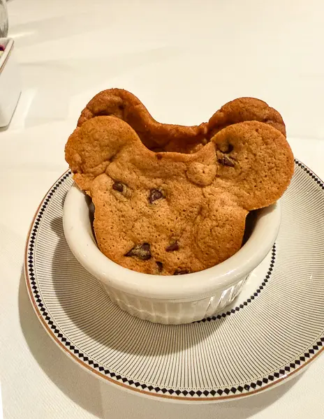 Mickey-shaped chocolate chip cookies served in a white ramekin at 1923 restaurant on Disney Treasure.