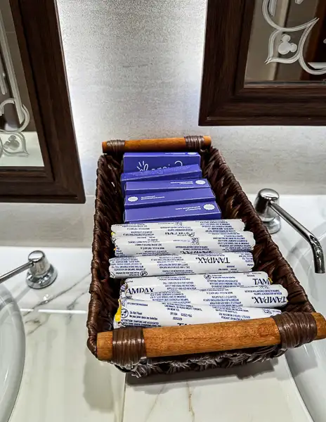 Basket of complimentary tampons and pads in a public restroom on Disney Treasure.