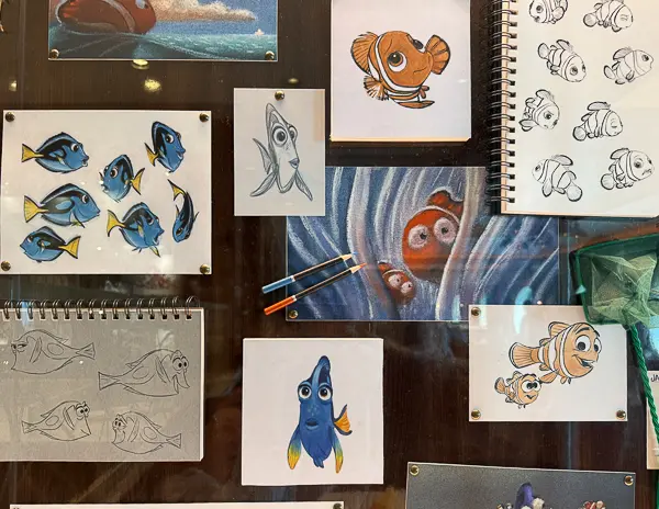 Display of Disney animation sketches and artwork featuring Nemo and Dory from Finding Nemo inside the 1923 restaurant on a Disney Cruise Line ship.
