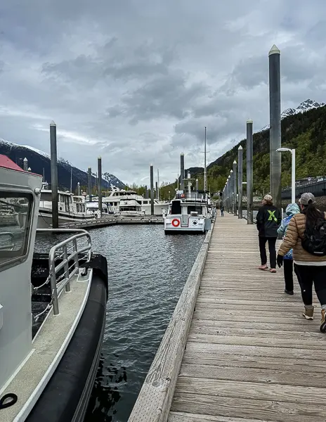 Tour guests / cruisers walking along the dock in Skagway to board the excursion boat.