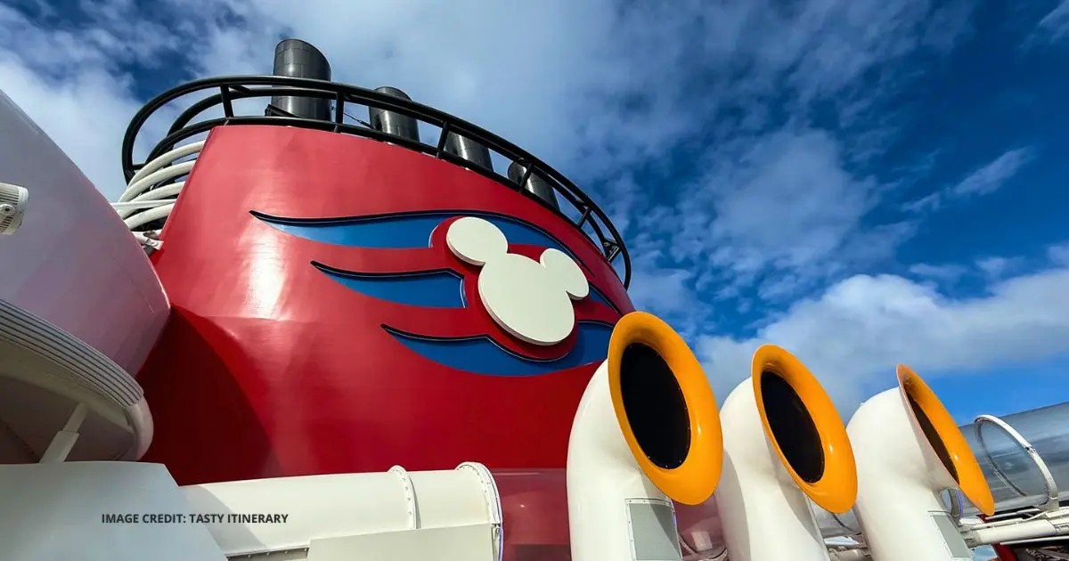 Disney Cruise Line ship funnel with Mickey logo and waterslides for an article about new alcohol, door decoration, and camera gear policy changes.