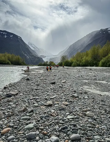 Tour guests / cruisers walking along the rocky shoreline after leaving the canoes to get a closer view of Davidson Glacier.