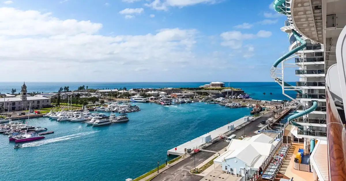 featured image: Bermuda cruise port at Royal Naval Dockyard viewed from a cruise ship, with turquoise water, marina boats, and the Dockyard shoreline.