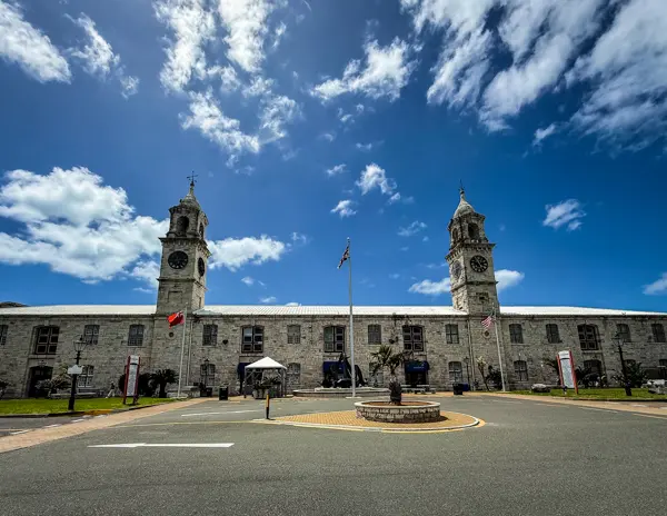 Clocktower Mall at Royal Naval Dockyard in Bermuda with twin clock towers and historic stone buildings.