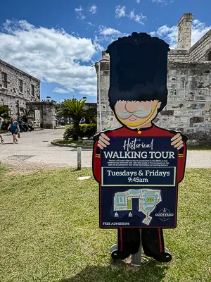 Sign for a free historical walking tour at Royal Naval Dockyard in Bermuda, with the tour schedule listed as Tuesdays and Fridays at 9:45 a.m.