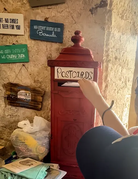 Red postcard mailbox inside Island Outfitters in Bermuda for mailing postcards from the Dockyard.