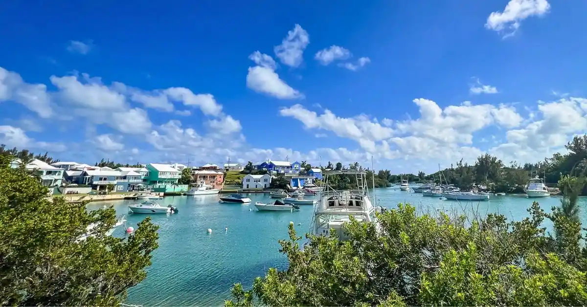 Scenic Bermuda harbor with colorful waterfront homes, boats, and turquoise water, featured in a post about Bermuda facts.