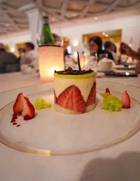 Fraisier dessert at Le Bistro on Norwegian Aqua with strawberries and pistachio garnish.