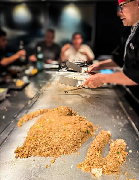 Chef cooking fried rice at Hasuki specialty restaurant on Norwegian Aqua during a teppanyaki dinner.
