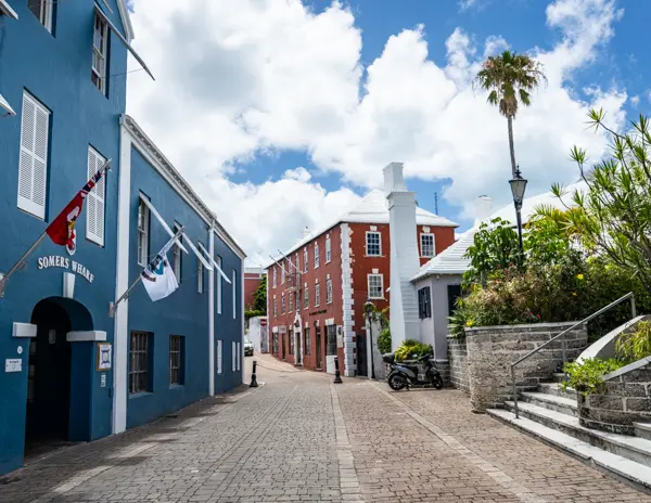Colorful historic buildings and white-roofed homes along a narrow street in St. George’s, Bermuda.