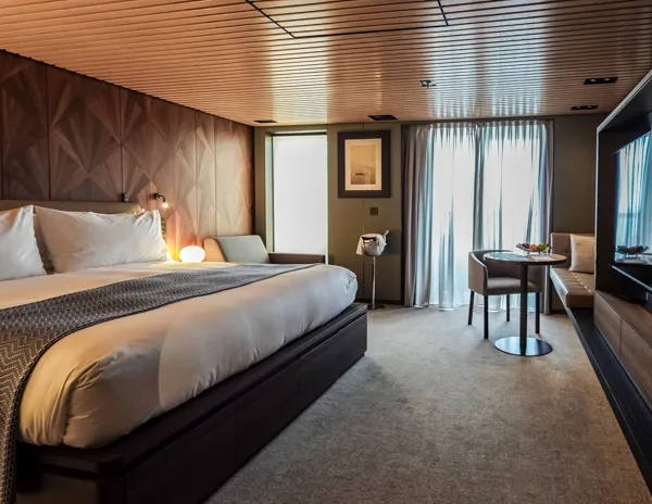 Norwegian Aqua Haven Penthouse Suite 13240 with king bed, sitting area, balcony doors, and modern stateroom layout.