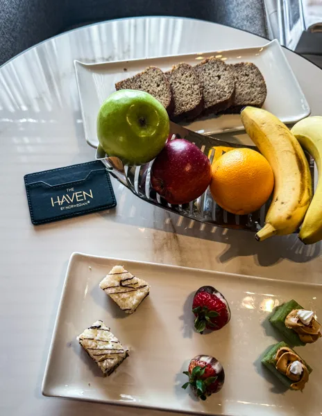 Norwegian Aqua The Haven butler-delivered afternoon snacks with fruit, banana bread, and small desserts.