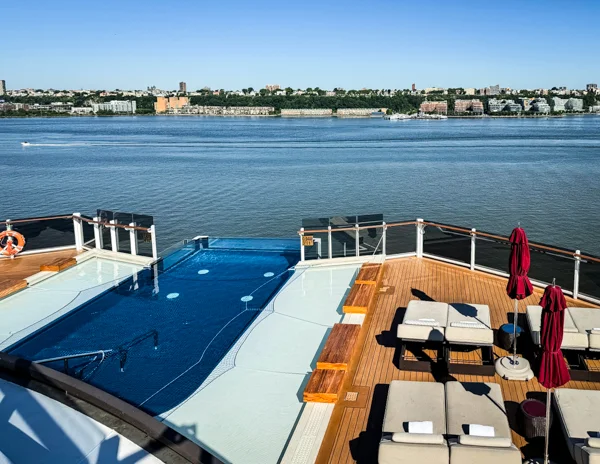 Norwegian Aqua Haven pool area with infinity pool, loungers, and waterfront views.