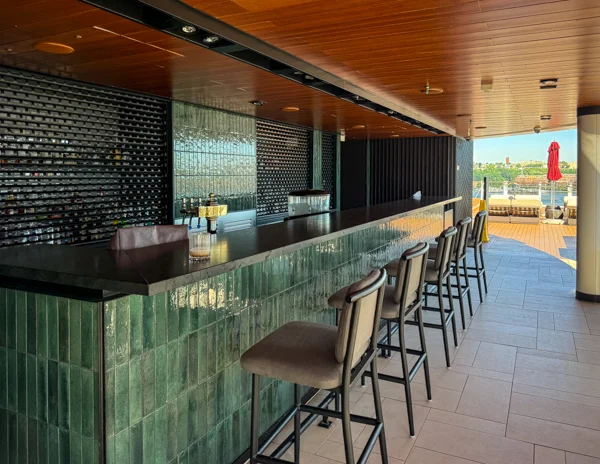 Norwegian Aqua The Haven pool deck bar with seating and outdoor lounge area.